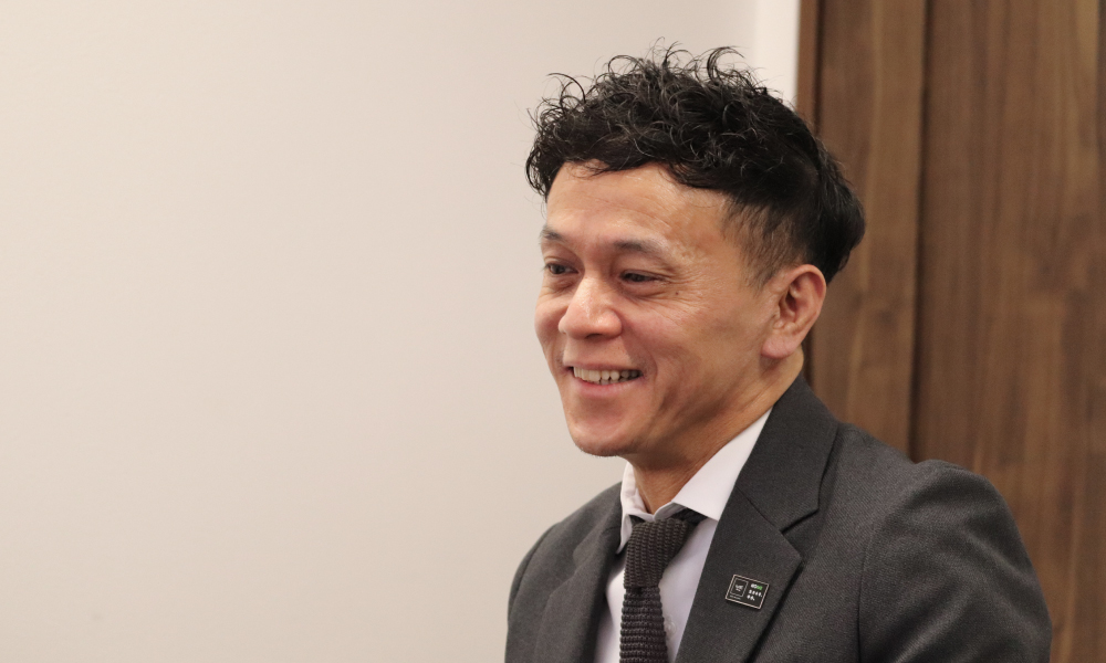 インタビューの最後に、地域のパートナーとして理想の暮らしを共に描く決意を語り、微笑む川名代表